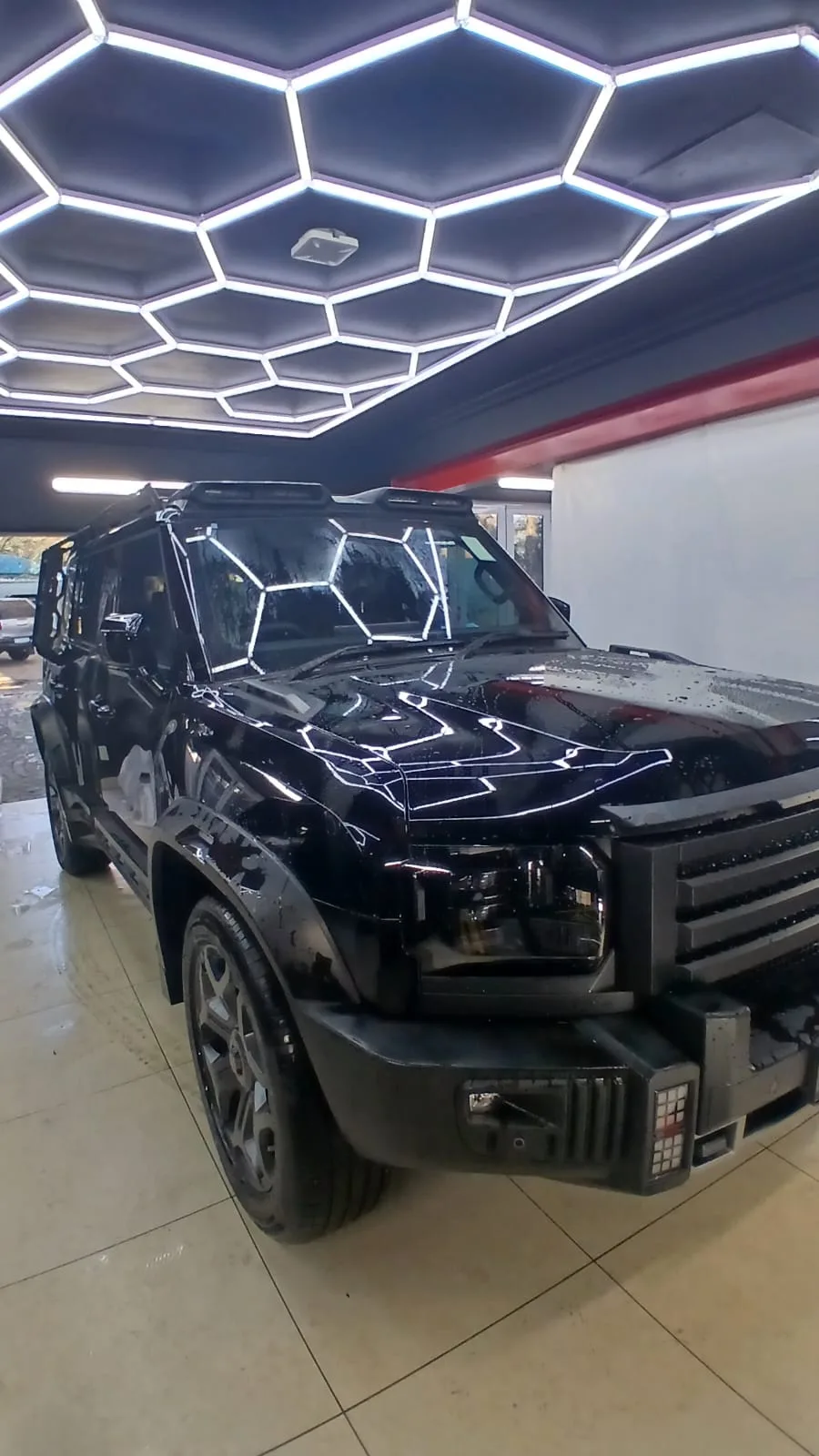 Black SUV with water droplets on its bonnet in the ClearGuard workshop