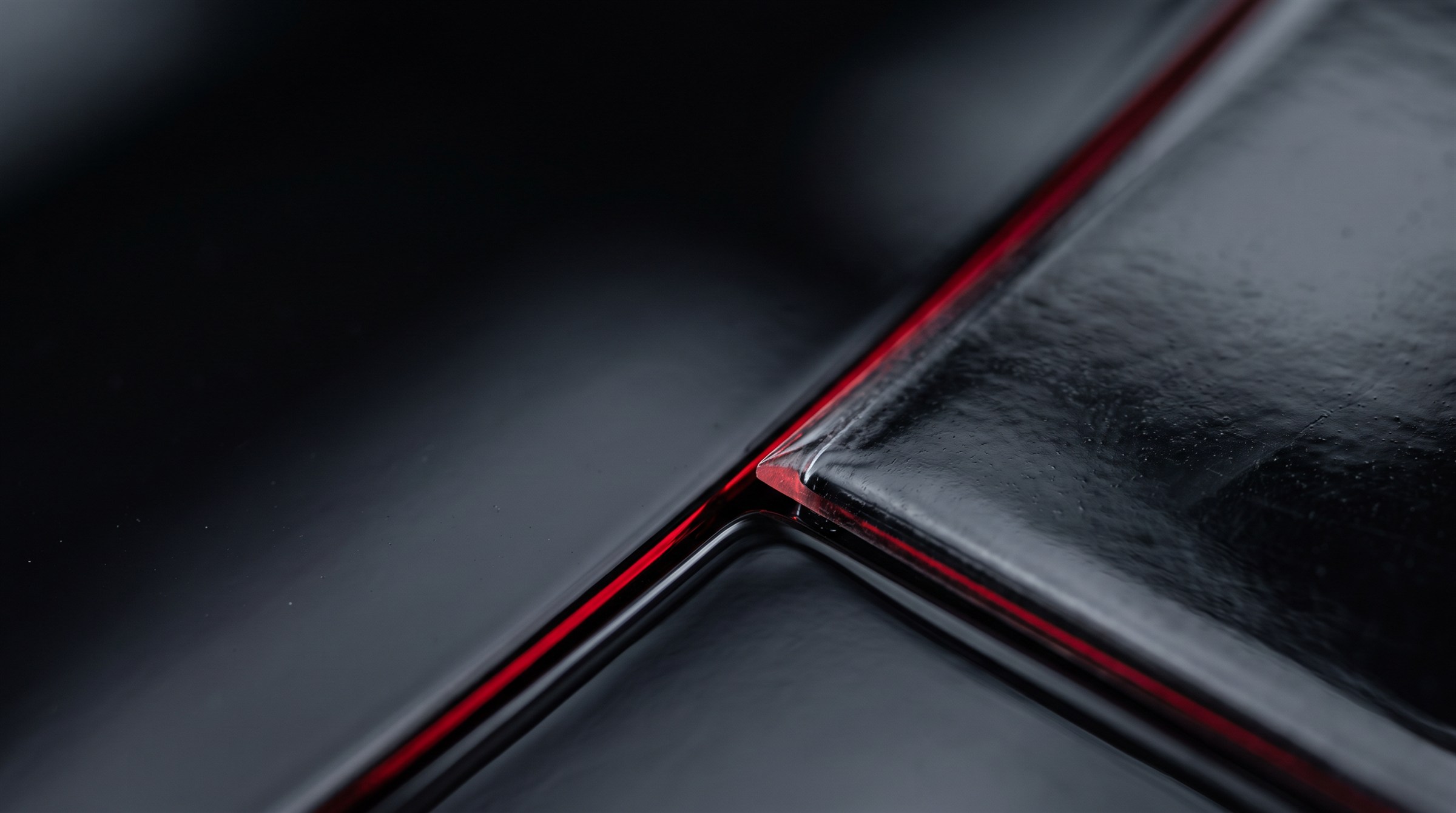 Close-up of clear paint protection film on a black car panel