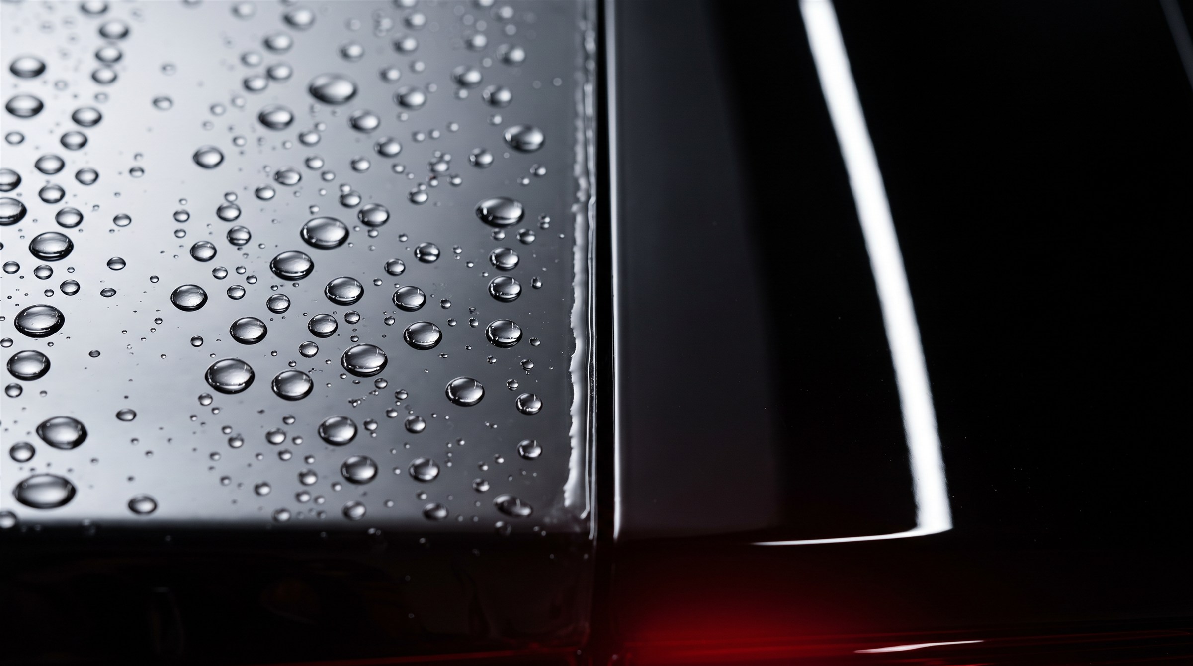 Water beading beside a glossy black protected panel